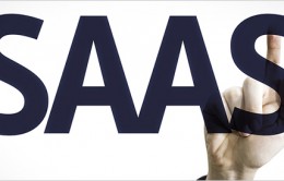 Business man pointing to transparent board with text: SAAS