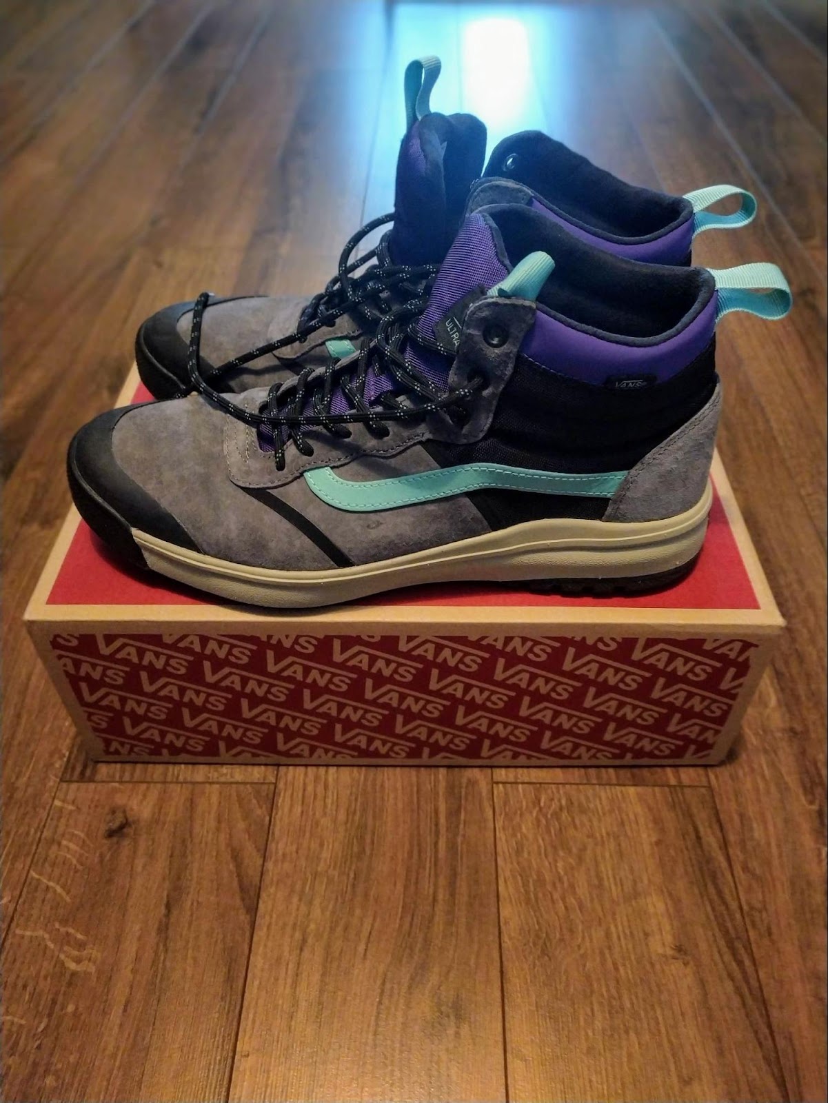 Purple, gray shoe with green stripe on top cardboard shoebox