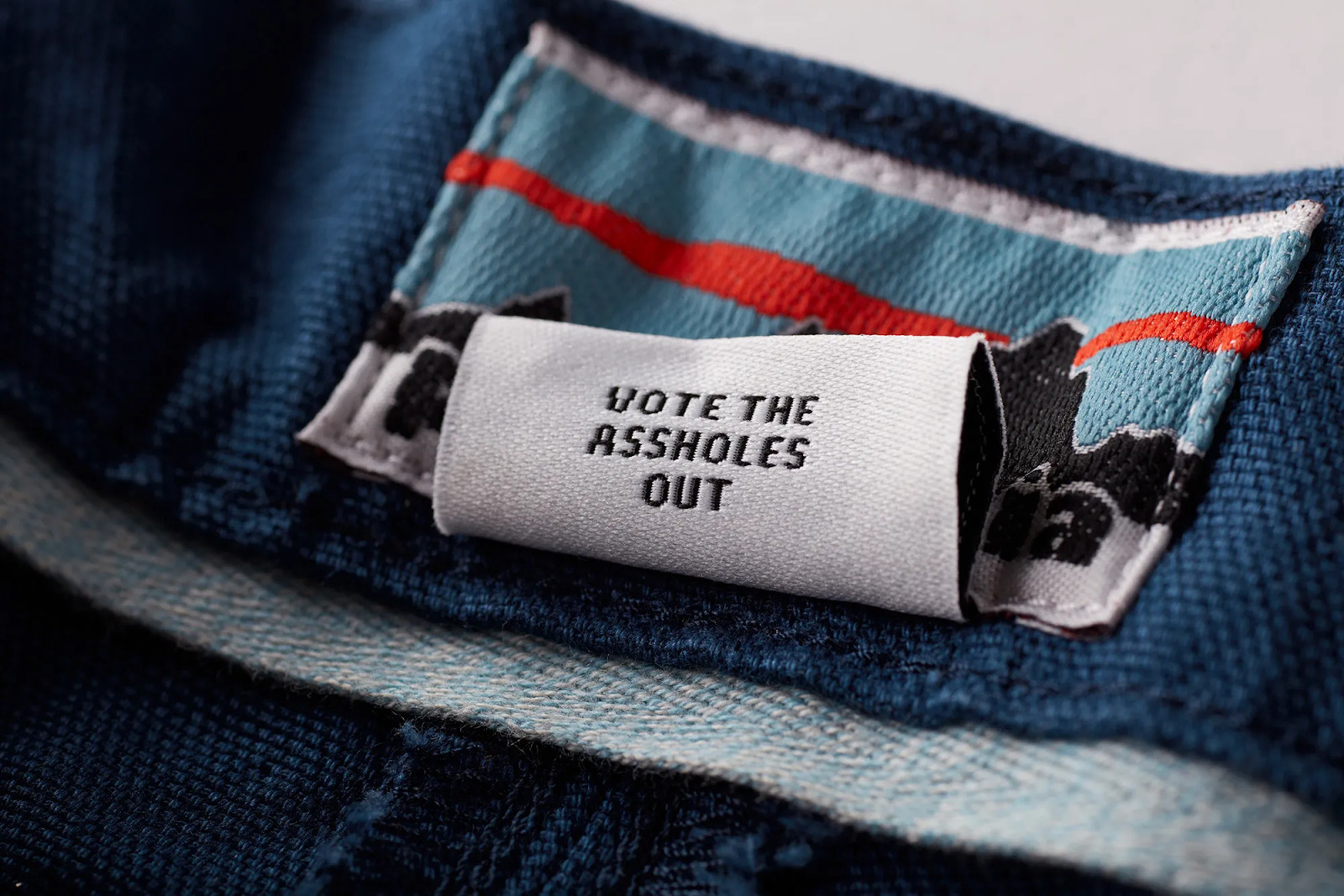 Clothing tag that reads, "Vote the assholes out" 