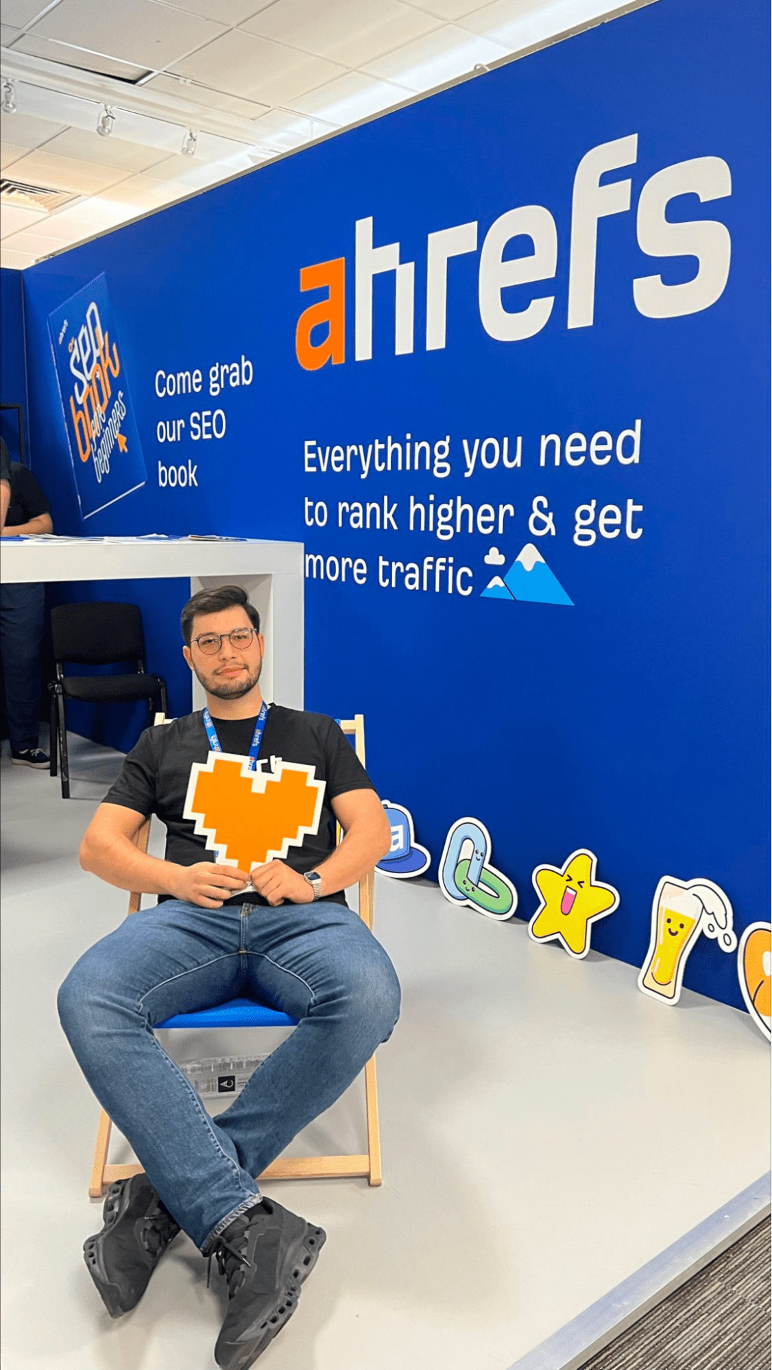 Andrei Țiț relaxing in a chair at Ahrefs' exhibitor stand
