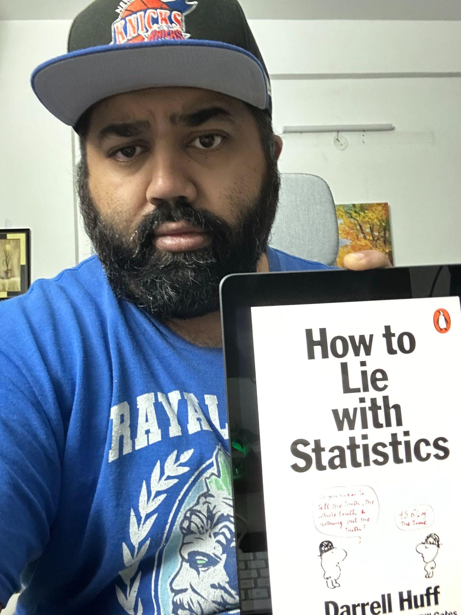 Ashwin holding the book How to Lie with Statistics