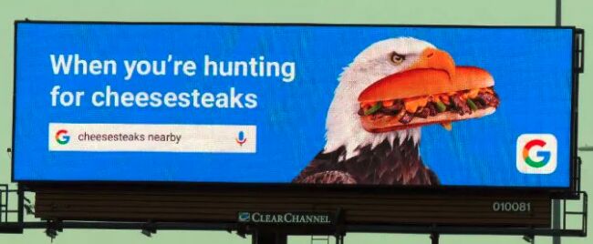 Billboard that includes a Google search for "cheesesteaks nearby".