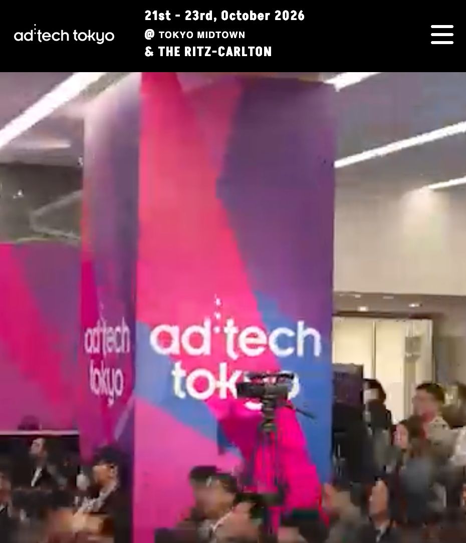 People gathered at an ad:tech Tokyo conference, with the logo visible on pink and purple pillars.