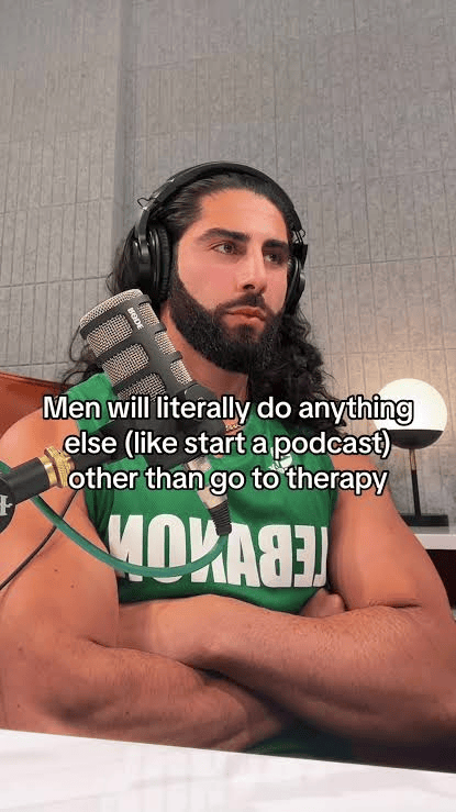 A man with a beard and long hair wears headphones, holding a podcast mic. Text: "Men will literally do anything else (like start a podcast) other than go to therapy."